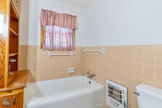 2757 Old Anson Rd, Abilene, TX 79603 - full bathroom with tile walls, a bath, toilet, heating unit, and a wainscoted wall