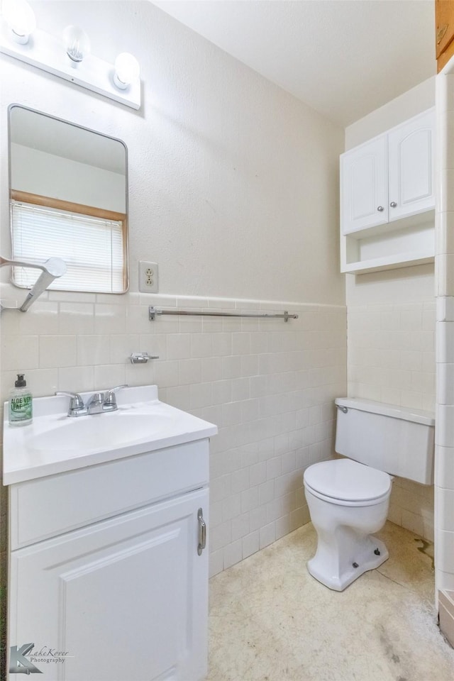 2757 Old Anson Rd, Abilene, TX 79603 - bathroom featuring tile walls, vanity, toilet, and a wainscoted wall