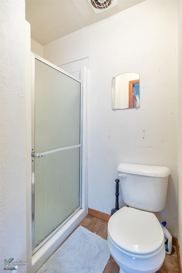2757 Old Anson Rd, Abilene, TX 79603 - bathroom with a stall shower, toilet, wood finished floors, and baseboards