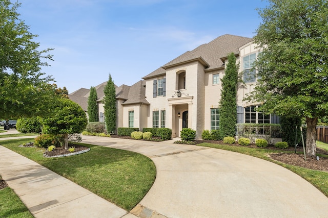2509 Oak Bend Ct, Southlake, TX 76092 - french country inspired facade with stucco siding, roof with shingles, a front lawn, and curved driveway