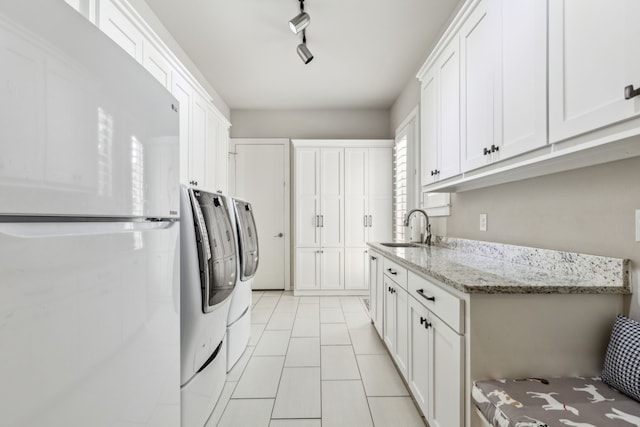2509 Oak Bend Ct, Southlake, TX 76092 - laundry area featuring washing machine and dryer, light tile patterned floors, and cabinet space