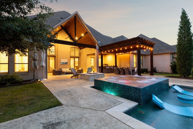 2509 Oak Bend Ct, Southlake, TX 76092 - pool at dusk with an outdoor living space with a fire pit, a patio area, and an in-ground hot tub