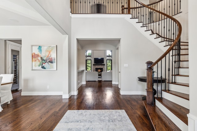 2509 Oak Bend Ct, Southlake, TX 76092 - foyer with wood finished floors, stairs, a stone fireplace, baseboards, and a high ceiling