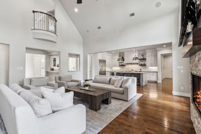 2509 Oak Bend Ct, Southlake, TX 76092 - living room featuring a fireplace, wood finished floors, a high ceiling, a ceiling fan, and recessed lighting