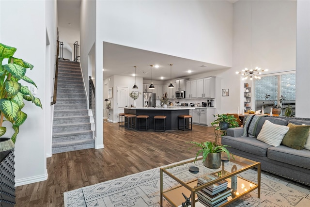 2529 Solomons Pl, Wylie, TX 75098 - living area featuring a towering ceiling, dark wood-style flooring, stairs, a chandelier, and baseboards