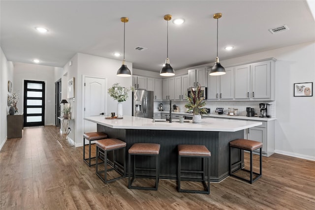 2529 Solomons Pl, Wylie, TX 75098 - kitchen with appliances with stainless steel finishes, baseboards, dark wood-style floors, a breakfast bar, and decorative backsplash