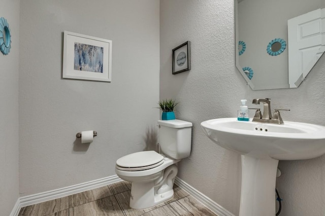 249 Noble Nest Dr, Midlothian, TX 76065 - half bathroom featuring toilet, wood finished floors, baseboards, and a sink