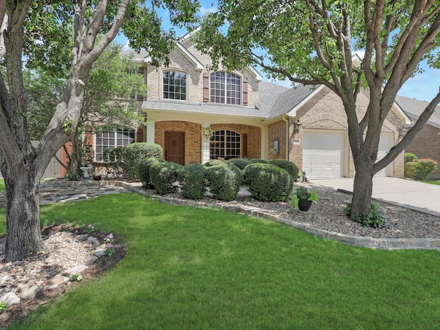 2525 Still Springs Dr, Little Elm, TX 75068 - traditional home featuring brick siding, concrete driveway, a front yard, an attached garage, and roof with shingles