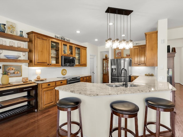 2525 Still Springs Dr, Little Elm, TX 75068 - kitchen featuring stainless steel appliances, a sink, brown cabinets, dark wood finished floors, and recessed lighting