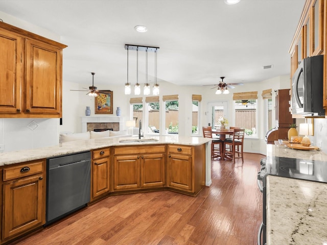 2525 Still Springs Dr, Little Elm, TX 75068 - kitchen with a ceiling fan, stainless steel appliances, a sink, a fireplace, and recessed lighting
