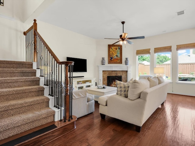 2525 Still Springs Dr, Little Elm, TX 75068 - living area featuring dark wood-style flooring, a ceiling fan, stairs, and a tile fireplace