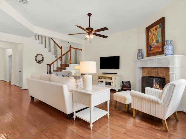 2525 Still Springs Dr, Little Elm, TX 75068 - living room with a ceiling fan, wood finished floors, a tile fireplace, and stairs