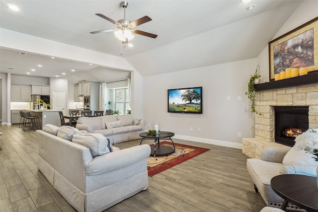444 Oliver Ct, Argyle, TX 76226 - living room with baseboards, lofted ceiling, wood finished floors, ceiling fan, and a stone fireplace