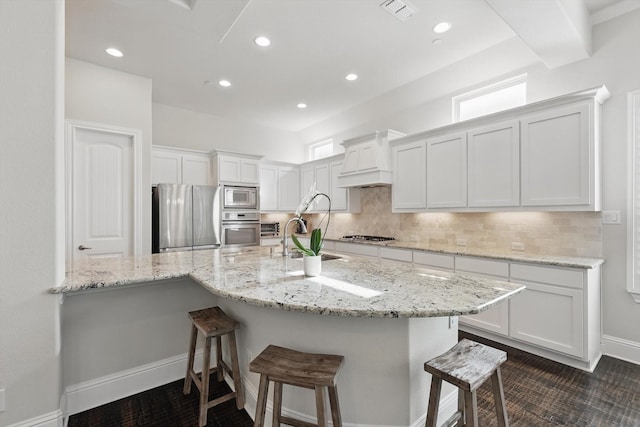 2812 Cedar Elm Dr, Carrollton, TX 75010 - kitchen with stainless steel appliances, premium range hood, a sink, white cabinetry, and a breakfast bar area