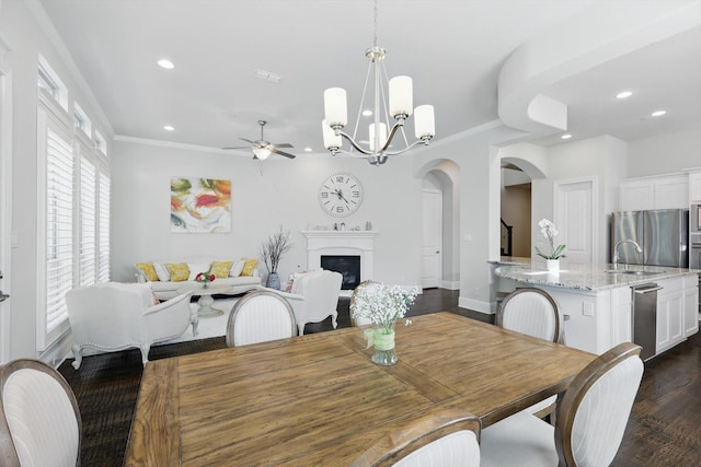 2812 Cedar Elm Dr, Carrollton, TX 75010 - dining room with arched walkways, a ceiling fan, recessed lighting, dark wood-style floors, and a fireplace