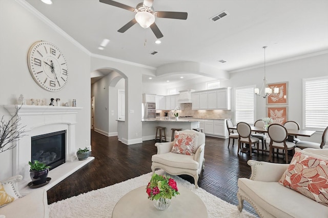 2812 Cedar Elm Dr, Carrollton, TX 75010 - living area featuring a ceiling fan, a chandelier, dark wood-style floors, a glass covered fireplace, and crown molding