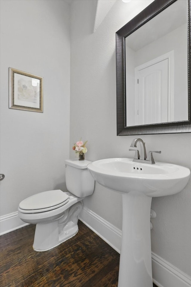2812 Cedar Elm Dr, Carrollton, TX 75010 - bathroom featuring baseboards, toilet, wood finished floors, and a sink