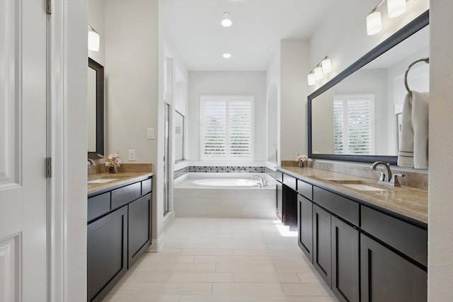 2812 Cedar Elm Dr, Carrollton, TX 75010 - bathroom featuring two vanities, a garden tub, a shower stall, and recessed lighting