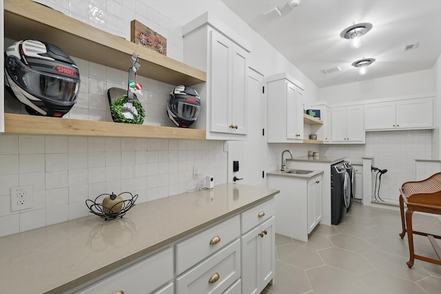 5913 Preston Way, Colleyville, TX 76034 - kitchen featuring open shelves, a sink, backsplash, washer and dryer, and white cabinetry