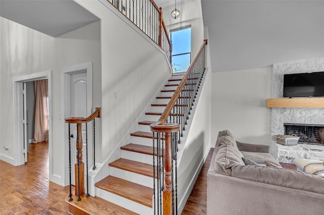 125 Wood Bend Ct, Weatherford, TX 76087 - staircase with a high ceiling, wood finished floors, baseboards, and a fireplace