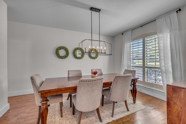 125 Wood Bend Ct, Weatherford, TX 76087 - dining room featuring healthy amount of natural light, wood finished floors, a chandelier, and baseboards