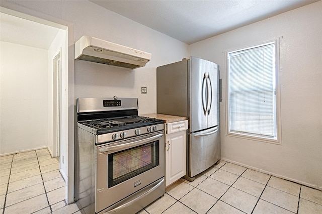 1705 Savoy St, Dallas, TX 75224 - kitchen with appliances with stainless steel finishes, under cabinet range hood, light countertops, white cabinetry, and light tile patterned floors