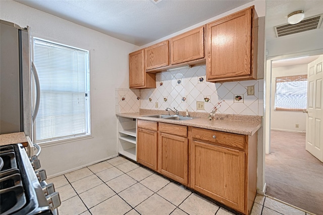 1705 Savoy St, Dallas, TX 75224 - kitchen featuring decorative backsplash, a sink, stainless steel appliances, light countertops, and light tile patterned flooring