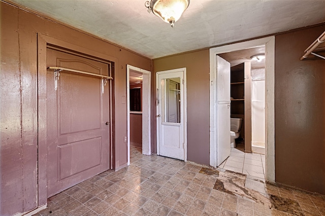 1705 Savoy St, Dallas, TX 75224 - unfurnished bedroom with stone finish floors and connected bathroom