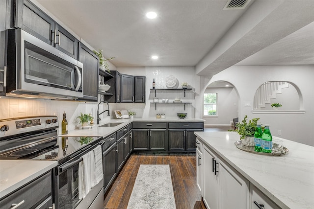 3321 NW 31st St, Fort Worth, TX 76106 - kitchen featuring appliances with stainless steel finishes, open shelves, recessed lighting, dark wood-style flooring, and light stone counters