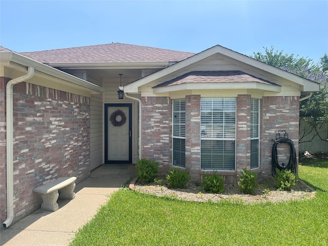5907 Aloe Ct, Arlington, TX 76017 - property entrance with a lawn, brick siding, and a shingled roof