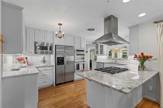 4304 Warnock Ct, Fort Worth, TX 76109 - kitchen featuring appliances with stainless steel finishes, island range hood, a sink, a peninsula, and light wood-style floors