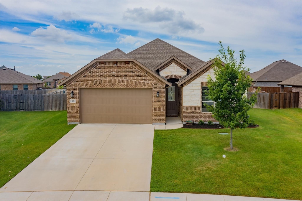 13 Bluebird Ln, Sanger, TX 76266 - french country style house featuring brick siding, a garage, driveway, and roof with shingles