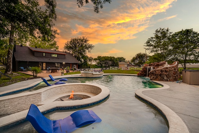1015 S Lowrance Rd, Pecan Hill, TX 75154 - pool at dusk with an outdoor fire pit, a patio area, and a pool with connected hot tub