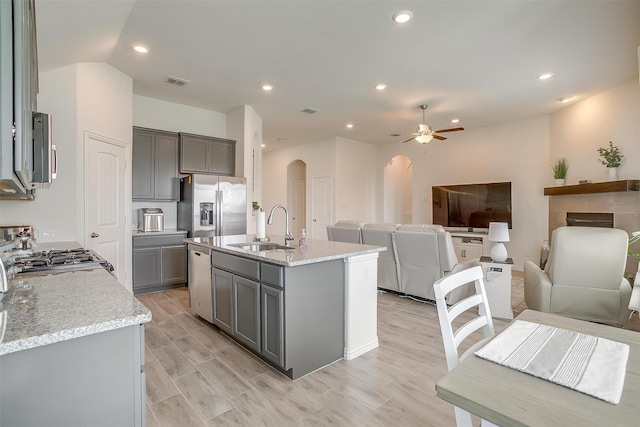 7200 Paso Verde Dr, Fort Worth, TX 76131 - kitchen with gray cabinets, arched walkways, a sink, appliances with stainless steel finishes, and open floor plan