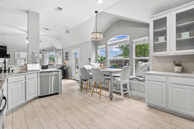 4679 Chasemoor Pl, Frisco, TX 75035 - kitchen featuring dishwasher, vaulted ceiling, open floor plan, decorative backsplash, and glass insert cabinets