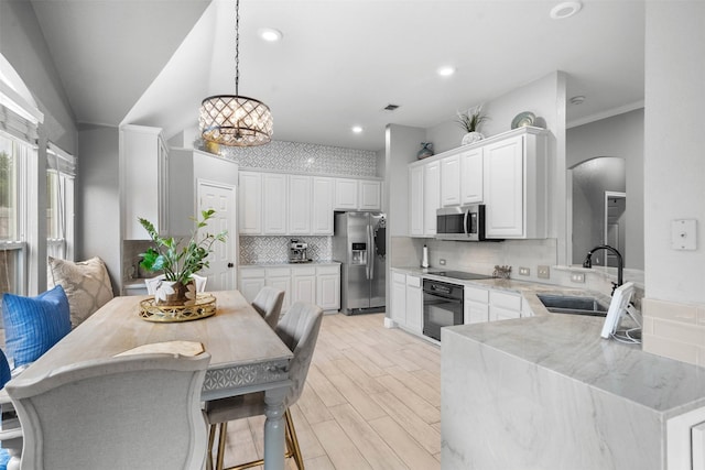 4679 Chasemoor Pl, Frisco, TX 75035 - kitchen featuring stainless steel appliances, a sink, arched walkways, light stone countertops, and backsplash