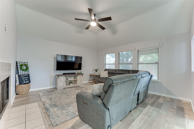 1900 Clear Creek Dr, Little Elm, TX 75068 - living room featuring ceiling fan, a tile fireplace, vaulted ceiling, light wood-style floors, and baseboards