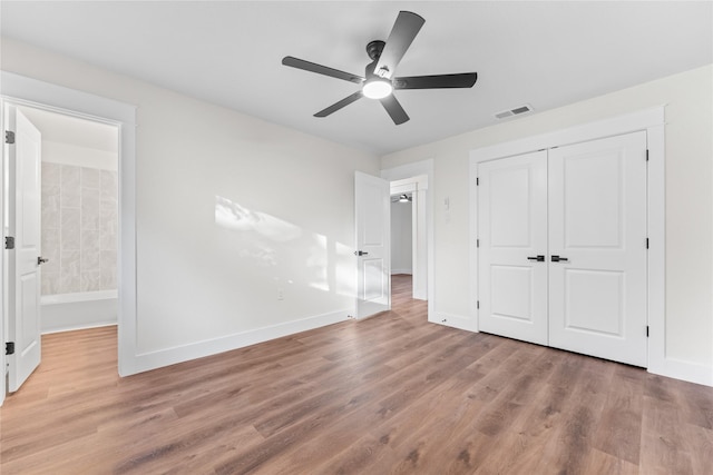 3408 Medallion Cir, Waco, TX 76706 - unfurnished bedroom featuring wood finished floors, baseboards, a closet, ceiling fan, and connected bathroom