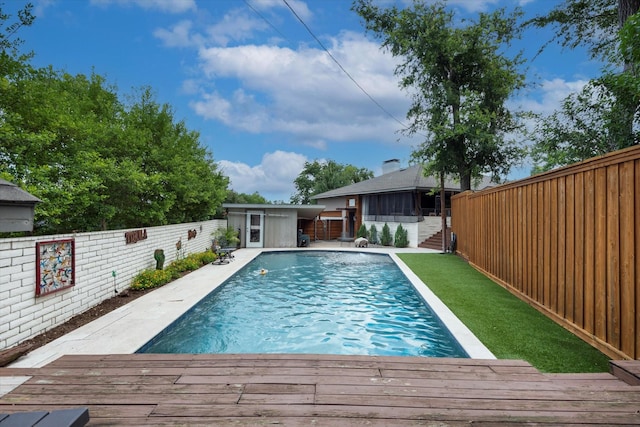 133 Lakeridge Dr, Dallas, TX 75218 - view of swimming pool featuring a wooden deck, a fenced backyard, and an outbuilding