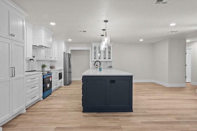 607 Audrey Ave, Waco, TX 76705 - kitchen featuring appliances with stainless steel finishes, premium range hood, light countertops, white cabinets, and recessed lighting