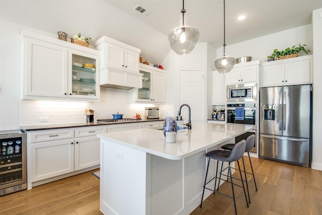 3717 Silver Birch Dr, Mckinney, TX 75071 - kitchen featuring appliances with stainless steel finishes, beverage cooler, a sink, backsplash, and light wood-style flooring
