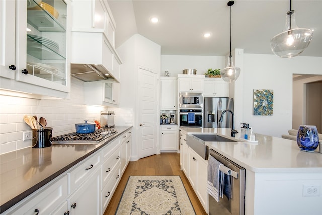 3717 Silver Birch Dr, Mckinney, TX 75071 - kitchen with stainless steel appliances, a sink, light wood finished floors, white cabinets, and decorative backsplash