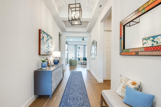 3717 Silver Birch Dr, Mckinney, TX 75071 - hallway featuring wood finished floors, a raised ceiling, a chandelier, and baseboards