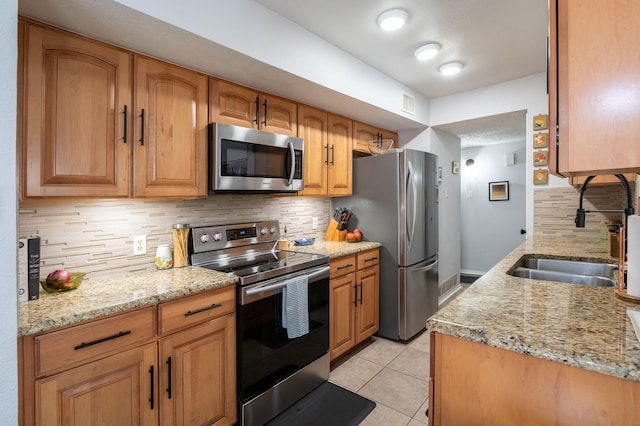 1903 Spies Springs Ct, Arlington, TX 76006 - kitchen with stainless steel appliances, backsplash, light tile patterned flooring, and light stone countertops