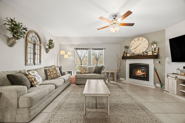 11013 Cobalt Dr, Aubrey, TX 76227 - living room featuring a glass covered fireplace, light tile patterned flooring, a ceiling fan, and baseboards