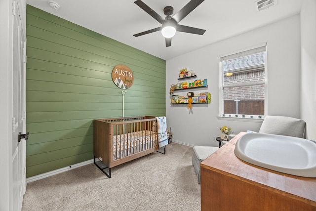 1224 Caprock Dr, Forney, TX 75126 - carpeted bedroom featuring wood walls, a nursery area, and ceiling fan