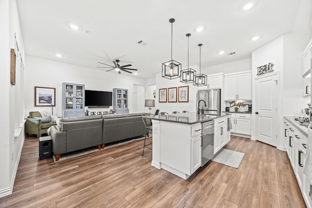 1224 Caprock Dr, Forney, TX 75126 - kitchen featuring appliances with stainless steel finishes, open floor plan, ceiling fan, dark countertops, and recessed lighting