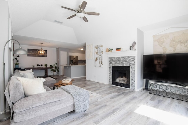 8713 Sabinas Trl, Fort Worth, TX 76118 - living area featuring ceiling fan, vaulted ceiling, light wood-style floors, a tiled fireplace, and baseboards