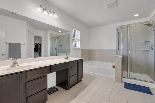 4506 Maplewood Ave, Balch Springs, TX 75180 - full bathroom with tile patterned floors, a stall shower, a spacious closet, a garden tub, and double vanity