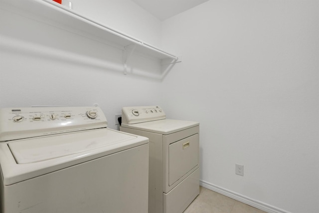 4506 Maplewood Ave, Balch Springs, TX 75180 - laundry area with washer and clothes dryer, baseboards, and light tile patterned floors